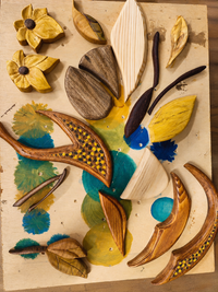 Butterfly in Flight taking shape on the workbench with carved wooden pieces arranged before final assembly.
