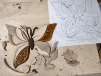 Butterfly Garden in progress with individually shaped wooden pieces arranged beside the original working template.